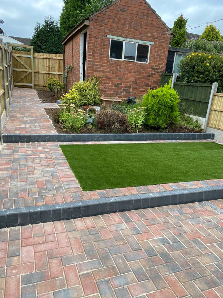 Case Study block paving with charcoal raised kerbs and artificial grass